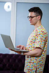 A young doctor is working on a laptop on a dissertation. The doctor in the clinic conducts online...