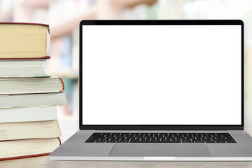 Template for online education - stocks of books next to the laptop with a blank white screen on a...