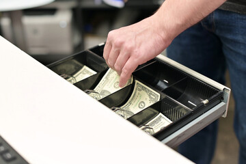 The seller opens the cashier of the store and collects change in dollars