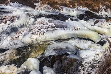 Fast river with ice and snow in late autumn