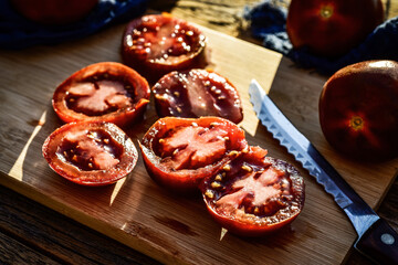 food preparation still life with sliced hybrid brown tomato on cutting board