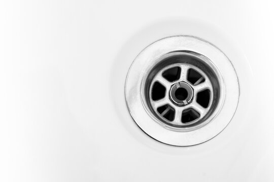 drain in a white household sink or bathtub. Sink hole for cork, stainless steel. Copy space