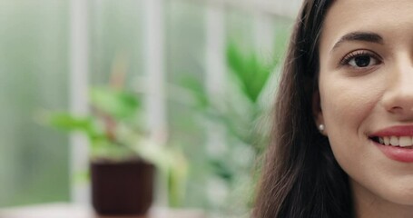 Close up shot of beautiful young cheerful woman with smile on face in good mood indoors. Half face of Caucasian pretty joyful female florist looking and smiling to camera. emotions concept