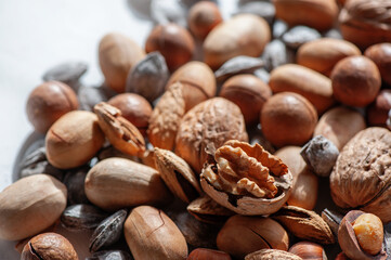assorted nuts. Different types of macadamia nuts, walnuts and hazelnuts lie in an even layer. Background of nuts