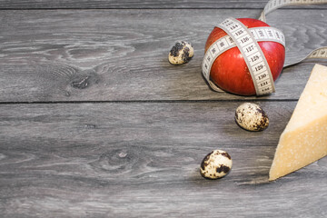 Notebook with table. Fat. Fruits, eggs, yoghurt and measuring tape on a gray background. Ketogenic diet, healthly food. Close up. Diet plan.