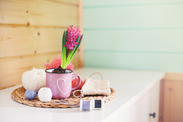 Working space for women. Knitting.Flower with pink hyacinth in a pot, balls of yarn, needles, scissors, a bouquet of tulips on the table. Women's hobby.