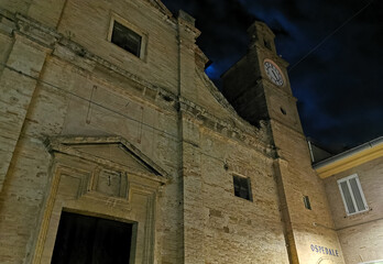 Facciata di una chiesa antica di notte con campanile luce della luna e nuvole in cielo