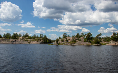 Fototapeta na wymiar lake, clouds and rocks landscape view at the entrance to Devil's Door at the Bad River, Ontario, Canada