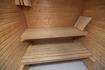 Naklejka na ściany i meble Close up view of sauna room interior. Wooden walls and seats. Health concept.