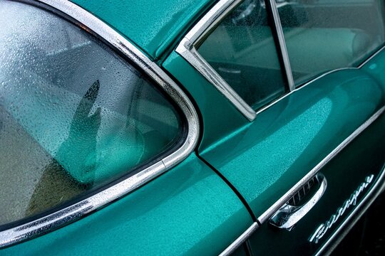 Detail of rear part of green Chevrolet Biscayne American muscle car after rain.