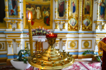 Lamp, candles in front of icons in the Orthodox Church. Burning wax candles, cross and icons in the monastery. Christianity. Altar in the church. The concept of the Orthodox faith.
