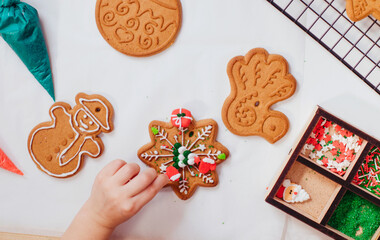 Closeup of kids hands decorating Christmas cookies with sprinkles