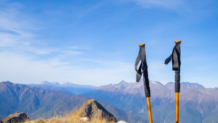Trekking poles at top of mountain with beautiful view of autumn mountains. natural background