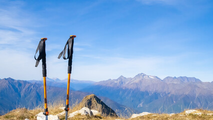 Trekking poles at top of mountain with beautiful view of autumn mountains. natural background