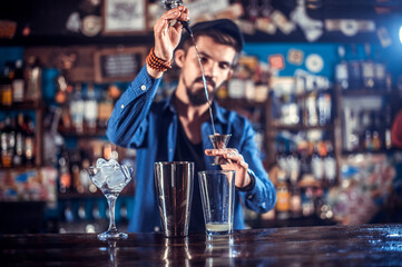Barman formulates a cocktail behind the bar