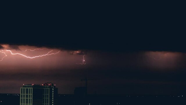 The storm with horizontal lighnings above city at night