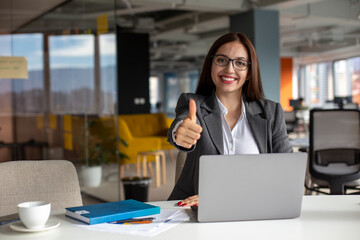 Fototapeta premium Portrait of the smiling businesswoman with thumb up.