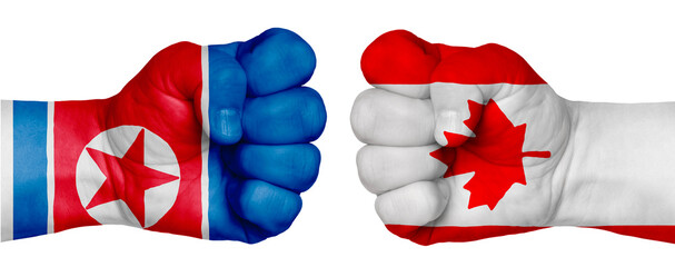 Two hands are clenched into fists and are located opposite each other. Hands painted in the colors of the flags of the countries. Canada vs North Korea