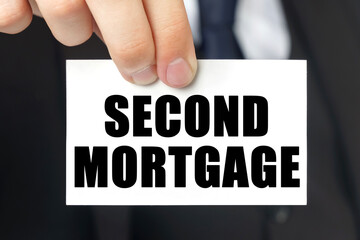 Businessman shows a card with the text SECOND MORTGAGE