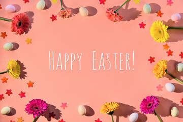 Fototapeta na wymiar Easter creative flat lay. Marzipan Easter eggs, gerbera flowers and confetti on warm pink paper