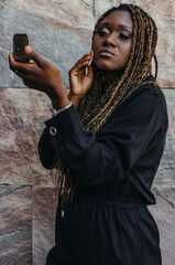 African model putting on makeup on the street