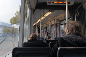 Interior and selected focus view at the back of elder female passenger sit in light rail tram and another passenger wear face protection mask during epidemic of COVID-19 virus with new normal concept.