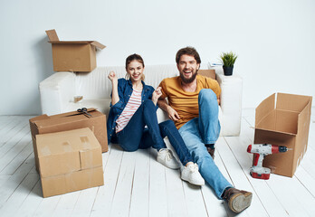 Fototapeta na wymiar Man and woman with empty boxes Moving to an apartment indoor interior