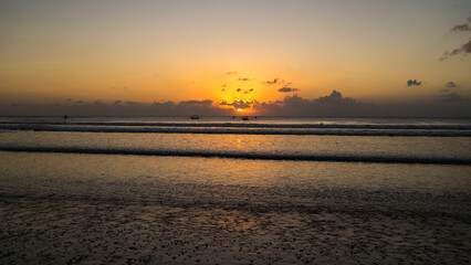 Beautiful golden sunset over the sea in Kuta beach, Bali Island, Indonesia. Freedom and spirituality concept, meditation on the beach, beautiful destination