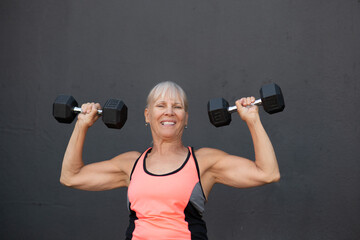 Fototapeta na wymiar Senior Woman Athletic Lifting Weights 