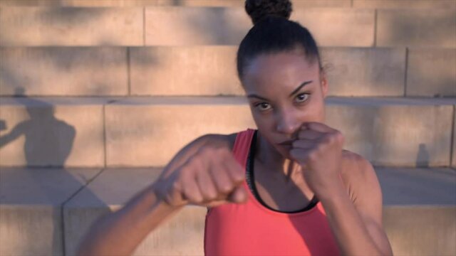 attractive african female boxer punching towards camera
