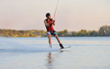 Wakeboarder surfing across a lake