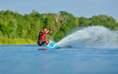 Wakeboarder surfing across a lake