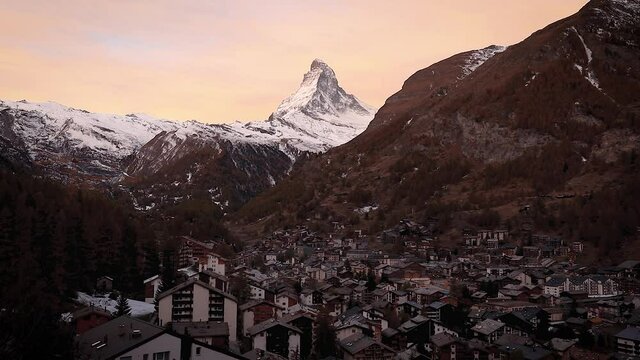 The Swiss village of Zermatt in Valais in autumn at sunrise, with the Matterhorn and the Alpine mountain range in the background.