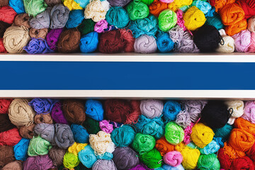 Сrocheting and knitting. Colorful multicolored skeins of yarn in the box on a blue background. Women's hobby.	