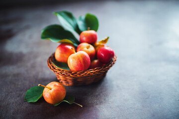 Ripe red small apples in the basket in  on dark table.  Autumn harvest. Macro