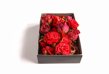 Red rose dry buds, flowers and petals in the opened cardboard box
