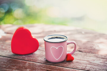 Pink mug with shape of hearts on wooden table. Big and small heart. Romantic, St Valentine's Day concept.

