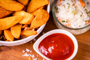 Tradition french fries from organic bio potato wedges with skin dip in ketchup