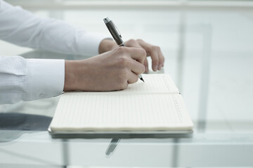 Obraz na płótnie Canvas Office worker's hand writes in notebook