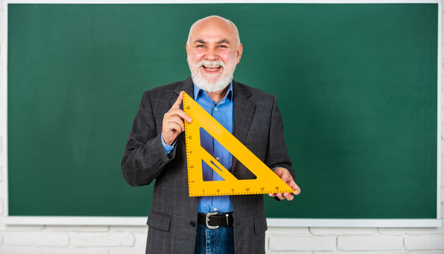 problem-solving skills. tutor man at blackboard. back to school. Math science concept with school lesson items. Mathematics at board. favorite subject. senior man teacher use math triangle tool