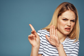 woman wearing striped t-shirt cropped view blue isolated background displeased facial expression