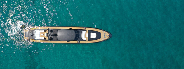 Aerial drone ultra wide photo of luxury yacht with wooden deck anchored in tropical exotic island...