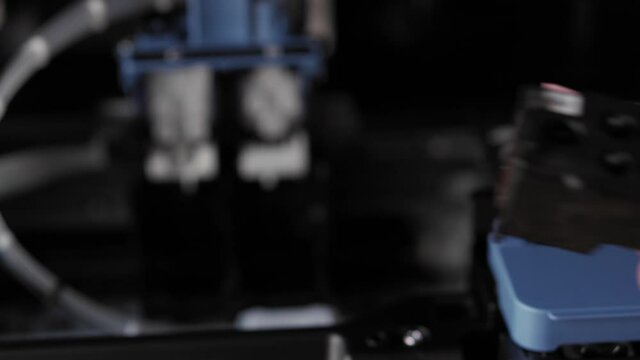 Video instruction, technology, press, media, office, stationery concept - close-up of male hands preparing new inkjet printer for launch. step 2: remove protective tape from cartridge filling holes