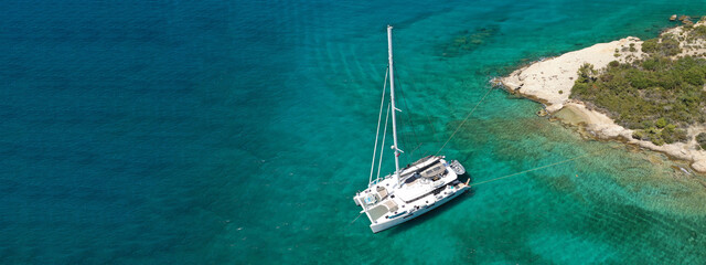 Aerial drone ultra wide photo of Catamaran boat anchored in popular Ionian island destination,...