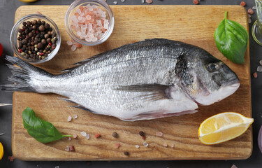 Raw dorado fish with spices cooking on cutting board. Closeup. View from above.