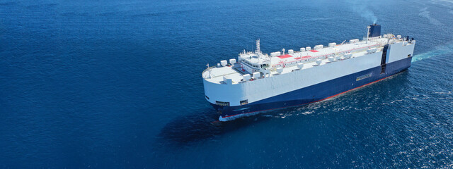 Aerial drone ultra wide photo of huge car carrier ship RO-RO (Roll on Roll off) cruising in...