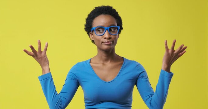 Regretful african american woman in doubts over yellow background