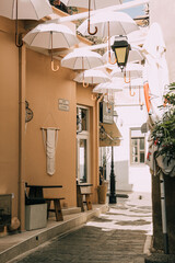 Białe parasolki w greckiej uliczce