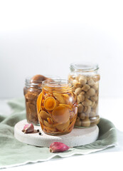 Glass jar with canned mushrooms. Fermented food on a white background