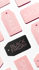 Top view on pattern of many pink and one black clothes tags on white background. Glamorous labels. Symbol of Black Friday sale and shopping. Flat lay.